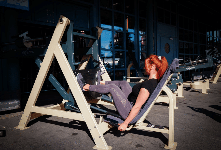 Frau trainiert an der Beinpresse im Outdoorbereich der Fitnessfabrik Hauptbahnhof in Darmstadt